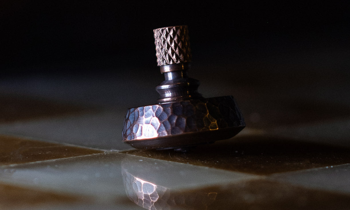 hammered copper spinning top with reflection