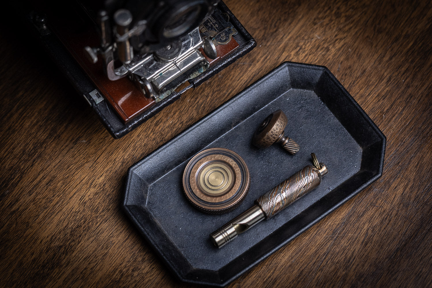 fiddle foundry fiddle coin, mokume Gane Whistle, and copper spinning top on Futagami stationery tray