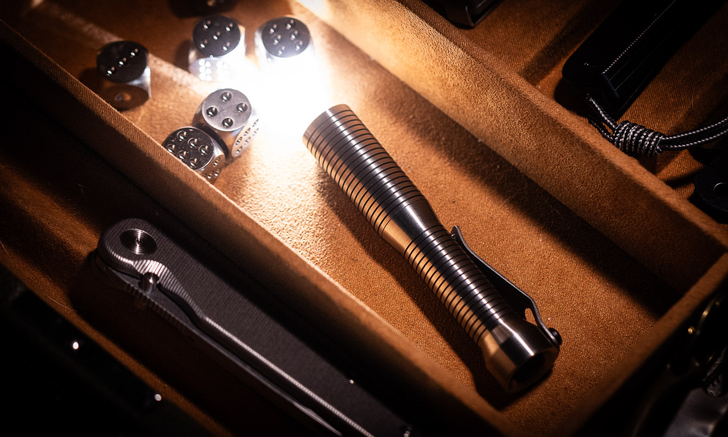 titanium flashlight illuminating titanium dice