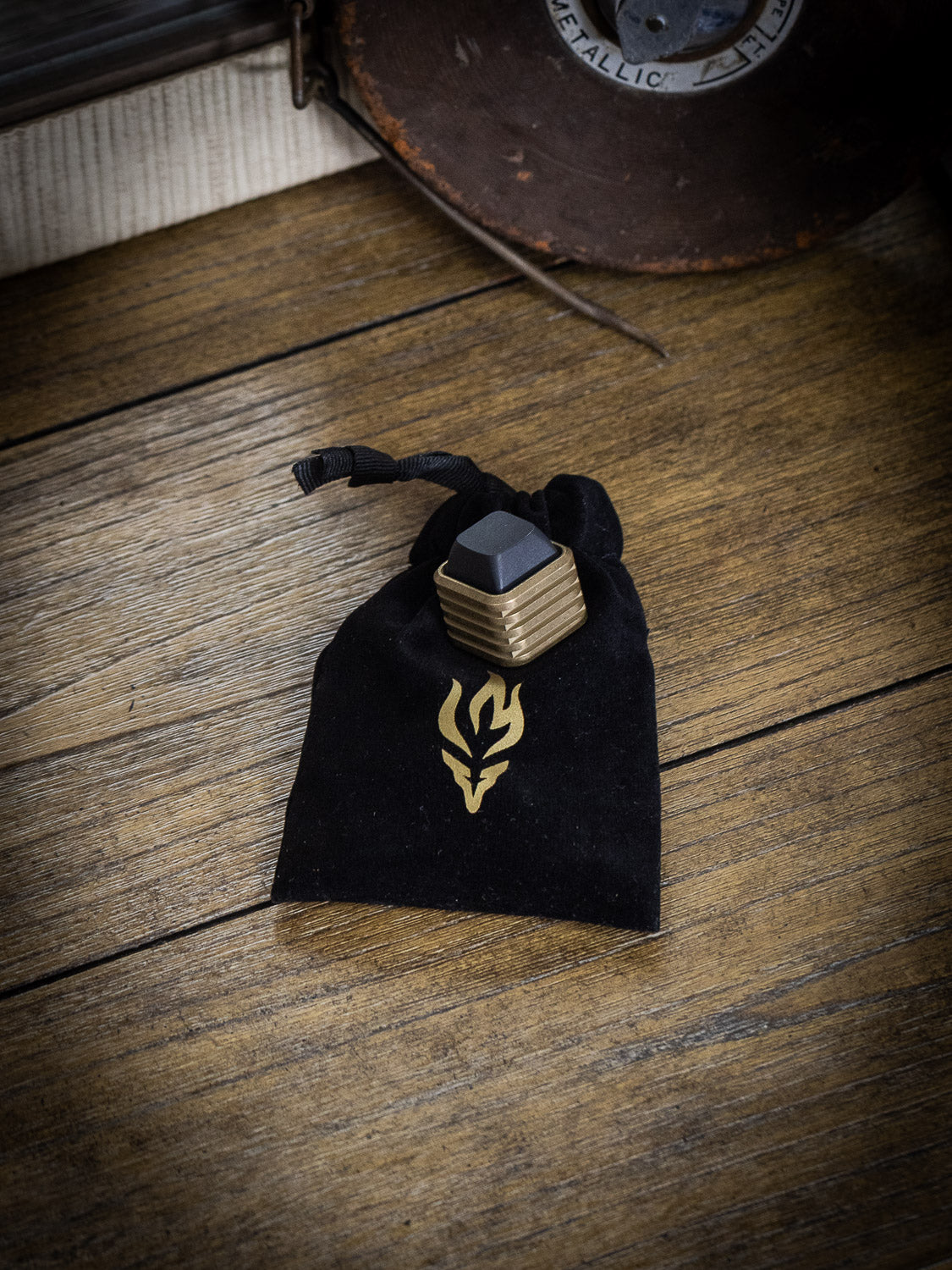 Last Manner torch emblem on a velvet bag next to a Last Manner box with black alligator wallet | Last Manner